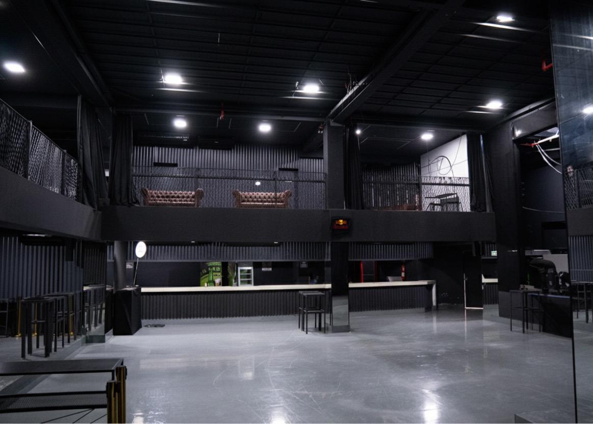 Vista ampla do salão principal com mezanino e bar